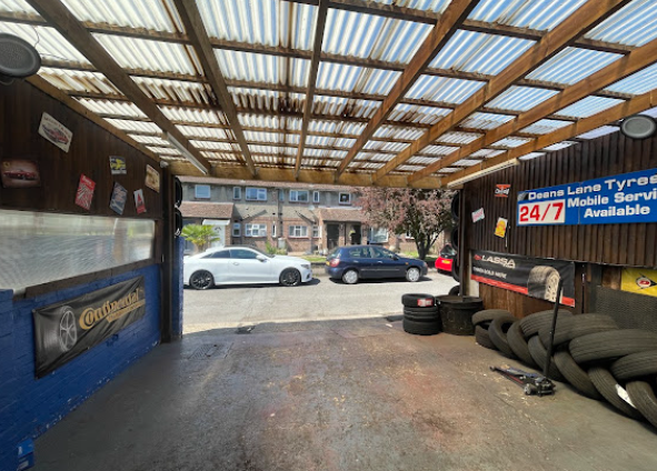 Covered fitting bay at Deans Lane Tyres with 24/7 mobile service sign